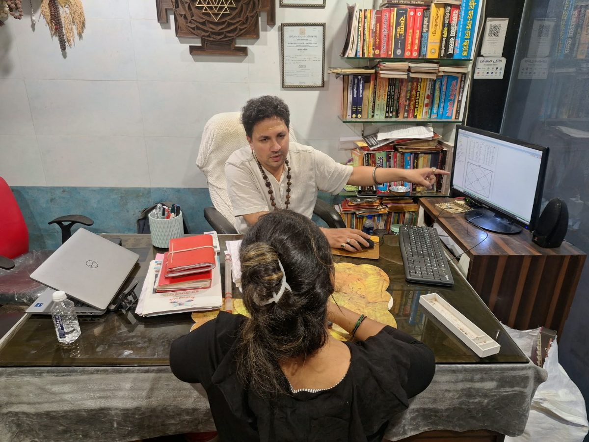 Acharya ji explaining a birth chart to a client